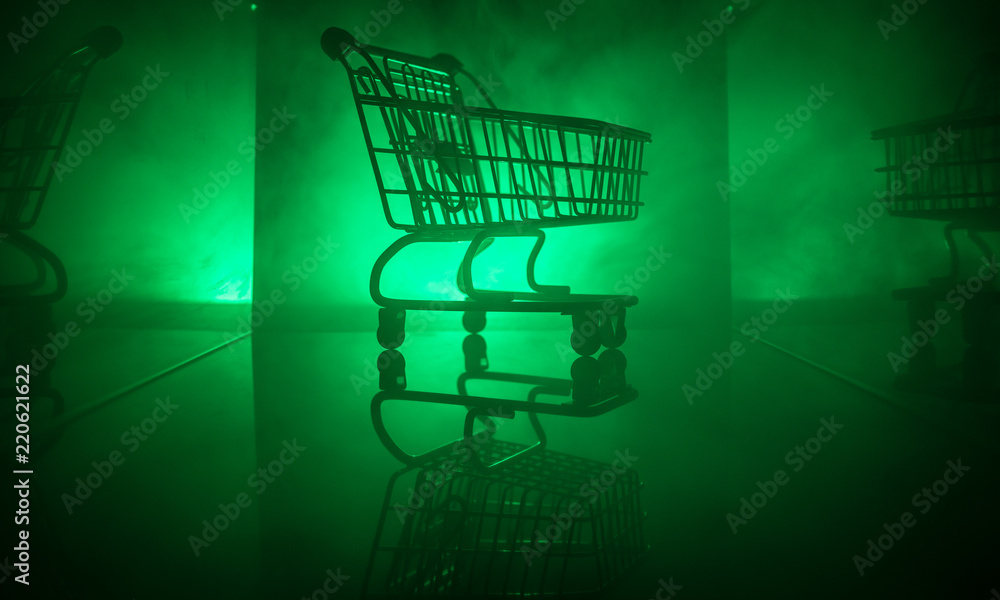 shopping trolley on dark toned foggy background with some copy space shopping trolley on dark toned foggy background with some copy space