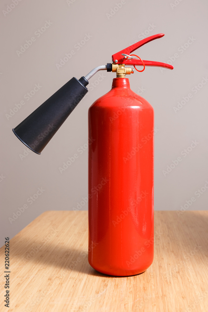 Fototapeta premium Fire extinguisher on the table in empty room