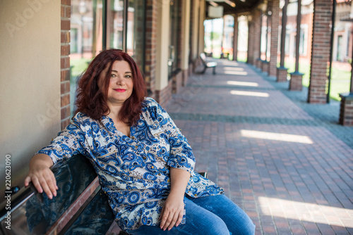 Bild auf Leinwand Portrait of attractive plus size mature woman in casual style walk at city at good sunny autumn day and thinking about something