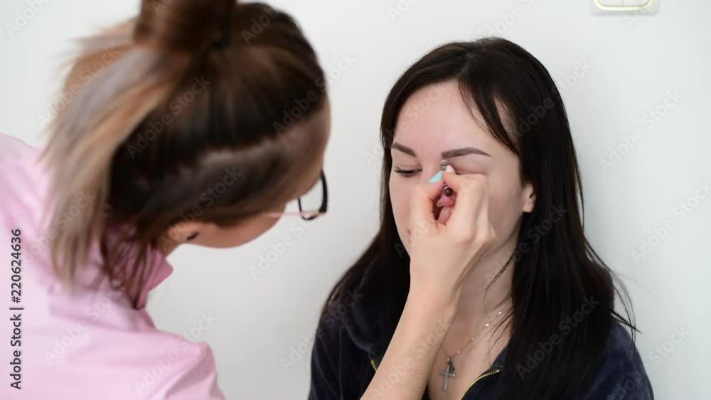make-up artist paints eyebrows to girl make-up artist paints eyebrows to girl