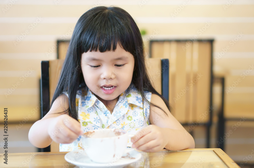 Asian children cute or kid girl smile white teeth and delicious hot cocoa or milk chocolate drink in white cup sloppy with fun and happy for breakfast in morning on table at home or cafe restaurant Asian children cute or kid girl smile white teeth and delicious hot cocoa or milk chocolate drink in white cup sloppy with fun and happy for breakfast in morning on table at home or cafe restaurant