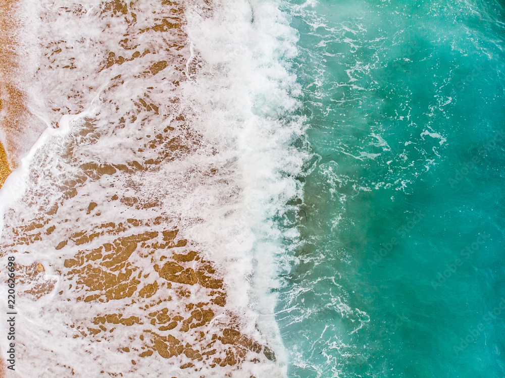 Top view aerial photo of an amazing sea waves with turquoise water from flying drone . Summer vacation holidays in Spain. Blue colours of the sea