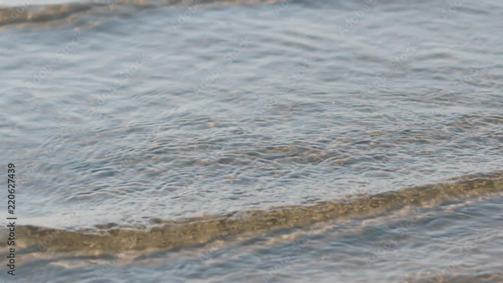 Slow motion small waves on a beach on a sunny day Slow motion small waves on a beach on a sunny day