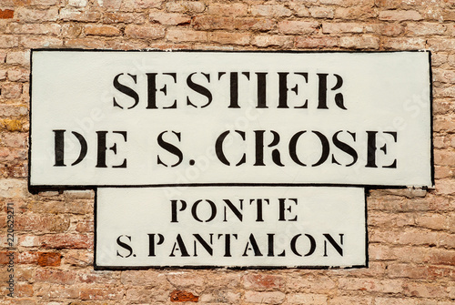 'Sestier de S. Crose ' (Saint Cross District) and 'Ponte S. Pantalon' (St Pantaleon Bridge) old traditional road sign on a wall in Venice