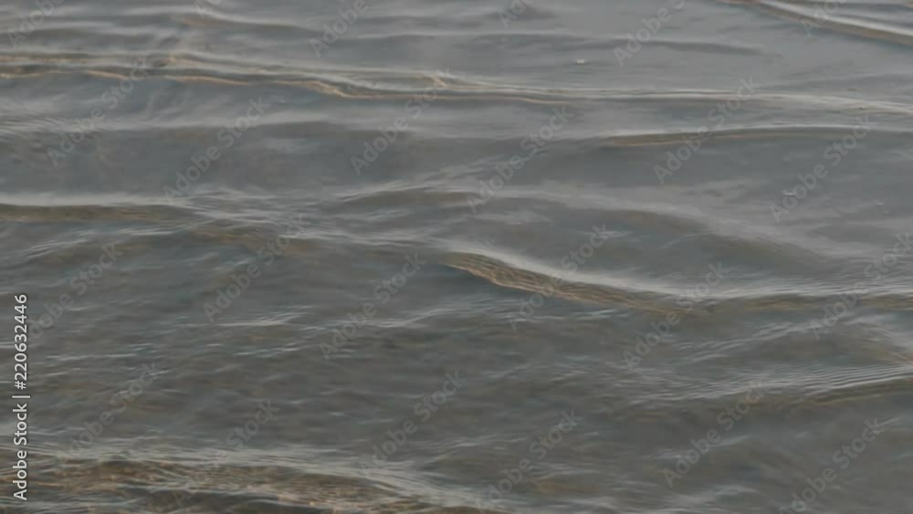 Slow motion closeup of small waves on a beach with caustics Slow motion closeup of small waves on a beach with caustics