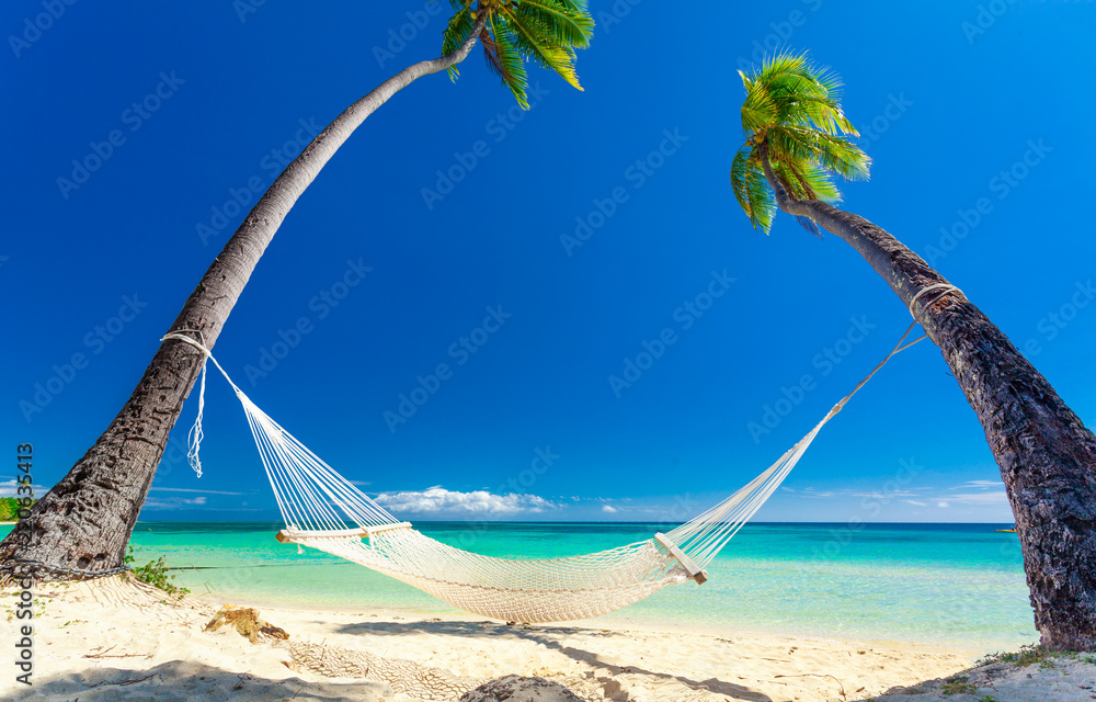 Naklejka premium Empty hammock in the shade of palm trees, Fiji Islands