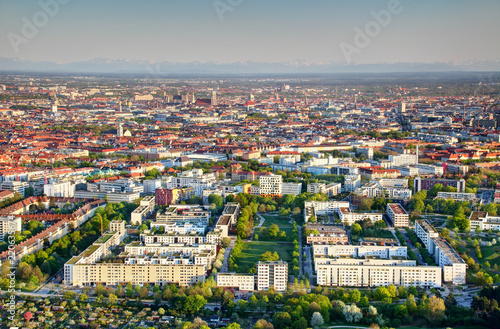 Sunny tower blocks and green parks in Oberwiesenfeld quarter in outskirts with downtown Altstadt and snowy Bavarian Alps in background, Milbertshofen Schwabing districts Munchen Bayern Germany Europe