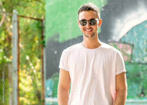 fashion guy posing outdoors in sunglasses