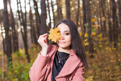 Fall  season  people concept - woman with yellow autumn leaf