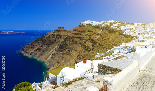 Greece, Santorini. Amazing view from famous sunset point on island in Aegean sea - Santorini over Oia - Ia village at the slope of volcano. Famous windmills and traditional greek white architecture. photo