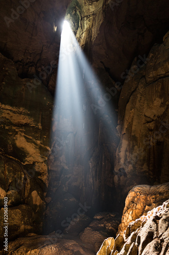 Shafts of sunlight from Mulu cave roof illuminate the chamber