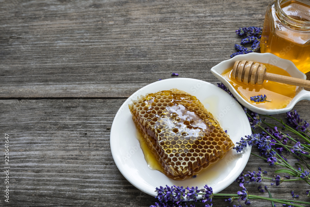 Honey with lavender flowers and honeycombs on rustic wooden table. healthy food. close up Honey with lavender flowers and honeycombs on rustic wooden table. healthy food. close up