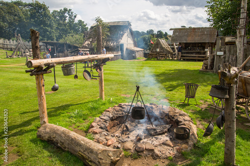 Essex, UK - 31 August, 2018: Main square with collective collective cooking fire in the Norman village. Educational centre for kids with historical activities and every day medieval life experience