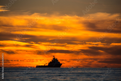 Ein Arbeitsschiff im norwegischen Atlantik fährt vor Sonnenuntergang