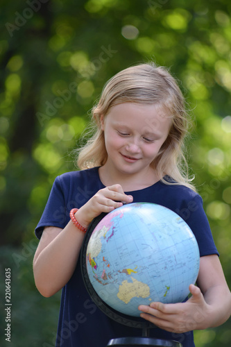 school girl holding globe