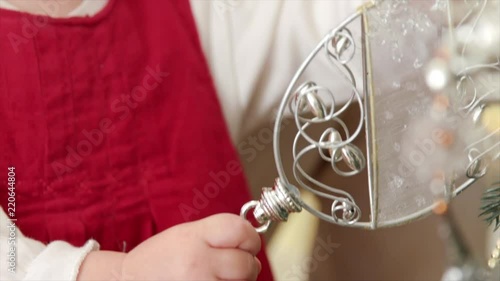 HD A cute little girl is getting acquainted with new Christmas-tree decoration. Close up shot photo