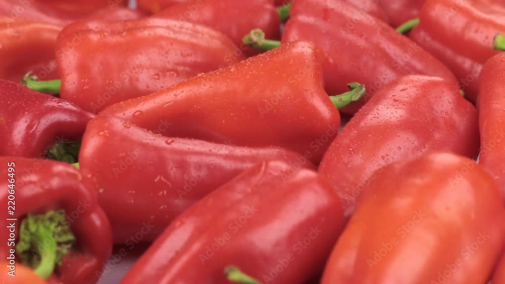 Rotation, close-up, falling drops of water on a ripe red peppers Rotation, close-up, falling drops of water on a ripe red peppers