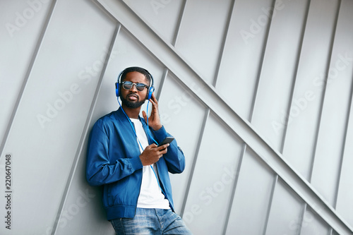 Fashion And Music. Man With Headphones And Phone In City photo