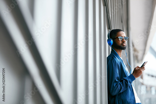 Fashion And Music. Man With Headphones And Phone In City photo