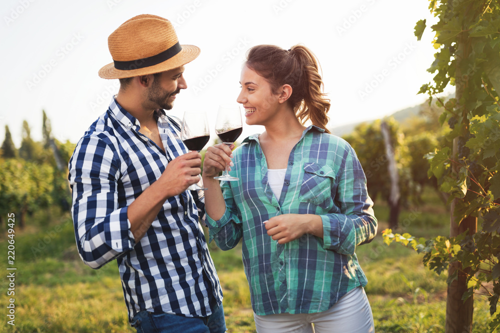 Fototapeta premium People sampling and tasting wines in vineyard