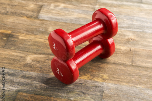 small red dumbbells for children and fitness lie on the floor