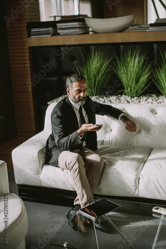 Middle-aged businessman usi...