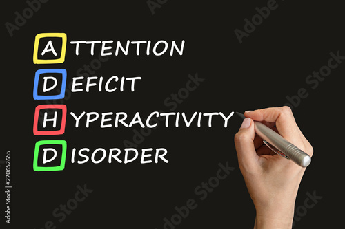 ADHD – attention deficit hyperactivity disorder handwritten by woman on black board. Attention Deficit Hyperactivity disorder concept. photo