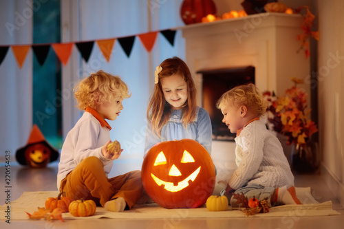 Kids carving pumpkin on Halloween. Trick or treat.