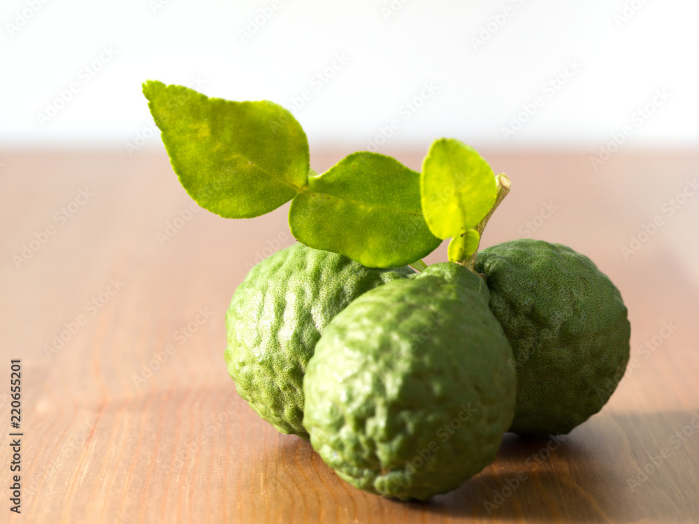 close up group of fresh bergamot with green leaves on wooden table. benefits of bergamot for beauty and health concept close up group of fresh bergamot with green leaves on wooden table. benefits of bergamot for beauty and health concept