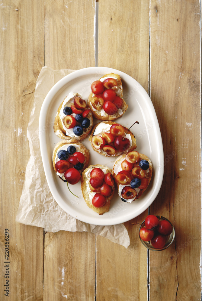 Bruschettas with cherry, blueberry, honey sauce and cream cheese Bruschettas with cherry, blueberry, honey sauce and cream cheese