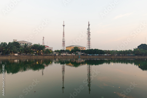 Telecommunication tower and the reflection at a riverside.