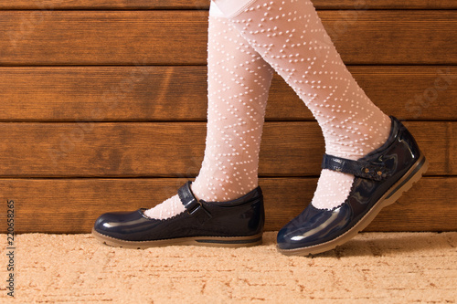 Little girl's feet in leather shoes . Close up