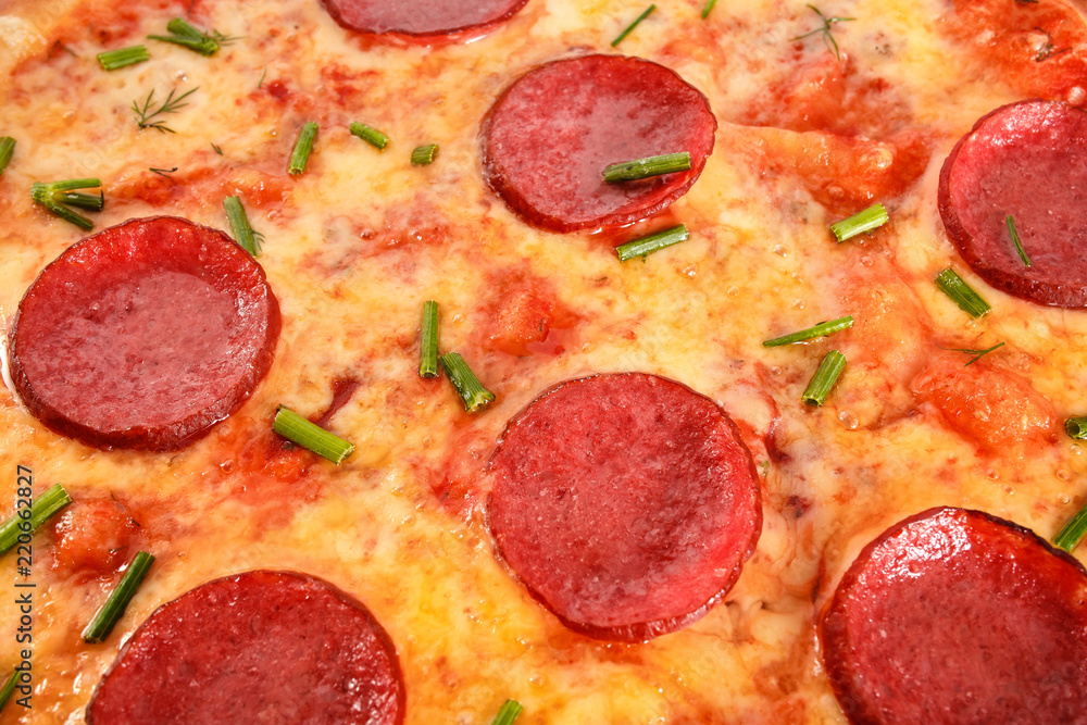 A Pepperoni Pizza with salami, sausage and greens isolated on white A Pepperoni Pizza with salami, sausage and greens isolated on white