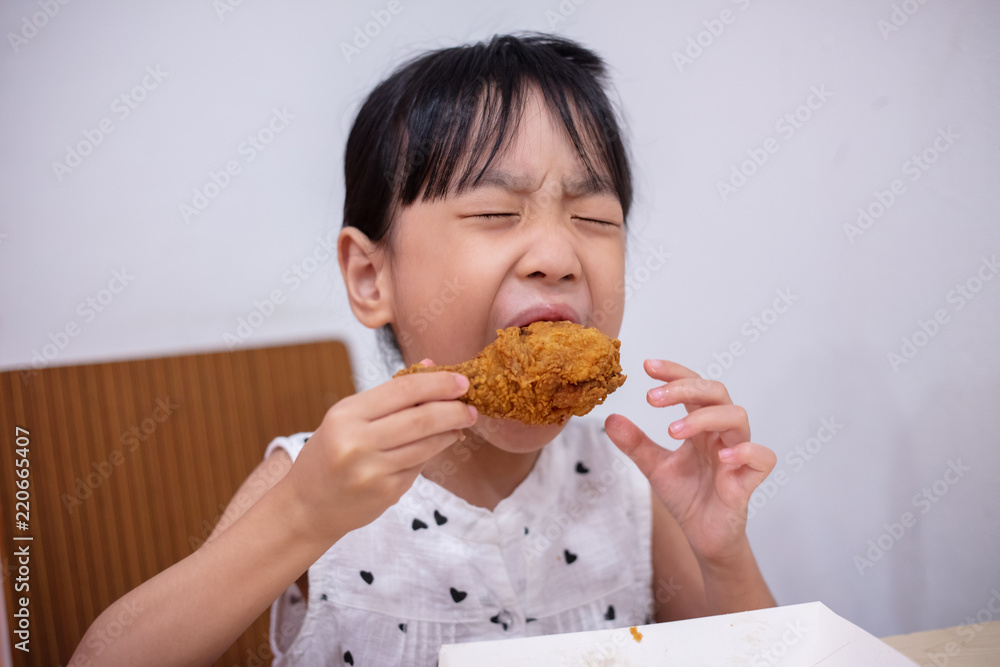 Asian Chinese little girl eating fried chicken Asian Chinese little girl eating fried chicken