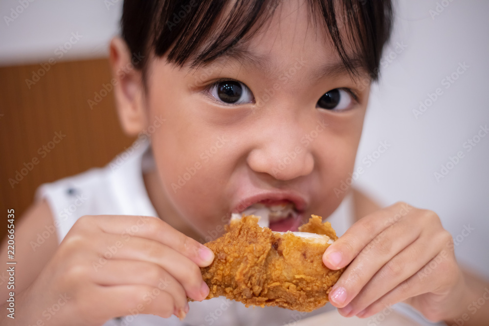 Asian Chinese little girl eating fried chicken Asian Chinese little girl eating fried chicken