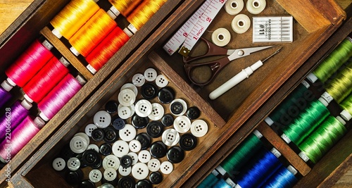 Sewing tools and accessories with colorful threads keep in the old wooden box
