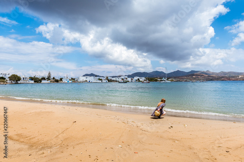 Pretty young woman on the summer beach in Pollonia village. Milos island, Greece photo