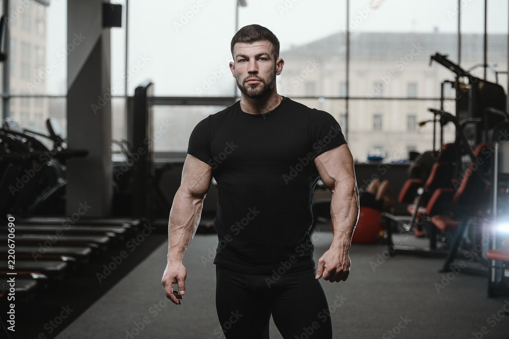 Brutal strong bodybuilder athletic men pumping up muscles with dumbbells Brutal strong bodybuilder athletic men pumping up muscles with dumbbells
