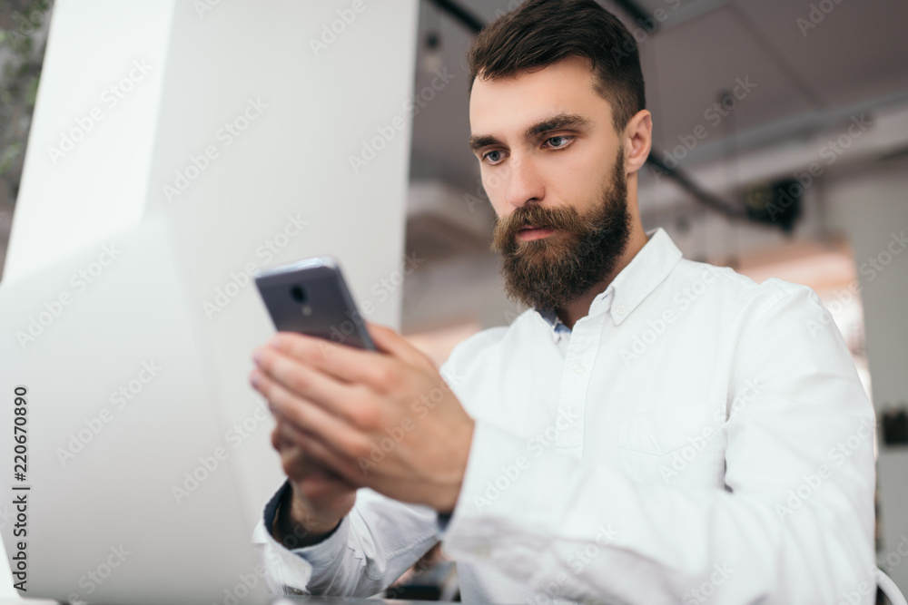 Bearded businessman using laptop computer and smartphone for project sitting in office space. Successful business. Attractive marketer write digital marketing plan, blog post and press release online. Bearded businessman using laptop computer and smartphone for project sitting in office space. Successful business. Attractive marketer write digital marketing plan, blog post and press release online.