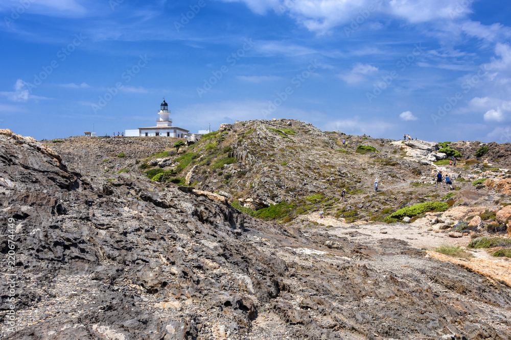 Spain, Catalonia, Cap de Creus: Panorama view of famous Spanish tourist destination with white lighthouse, rocky cliff and cloudy sky in the background . concept travel nautical destination landscape