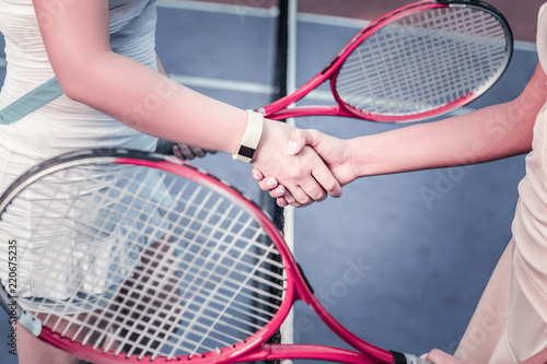 Enjoy game. Close up of female tender hands shaking and taking rackets © zinkevych