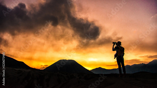 Photographer taking photos on beautiful moment mountains at Sunset