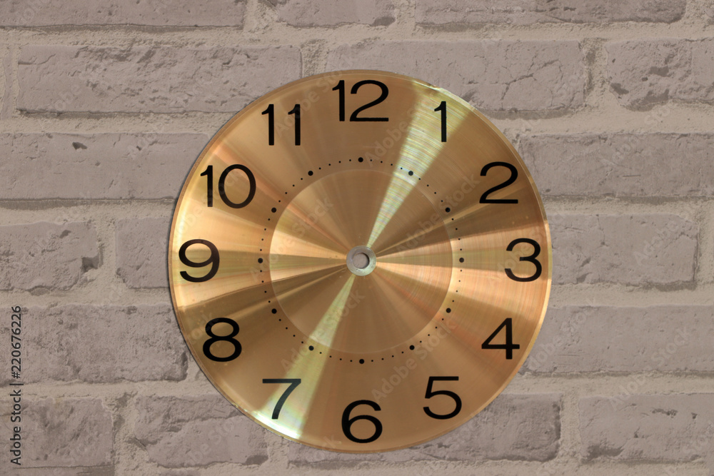 The round watch face no clock hands on grey brick pattern background