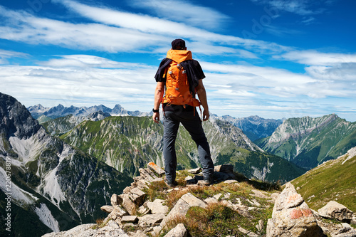 Mann genießt die Aussicht auf die Alpen vom Gipfel eines Berges