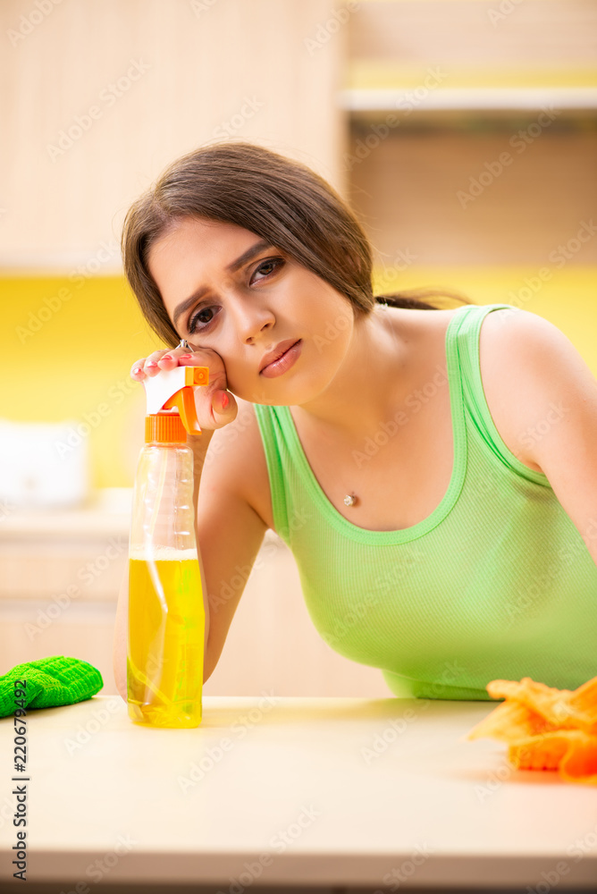 Young beatifull woman polishing table in the kitchen Young beatifull woman polishing table in the kitchen