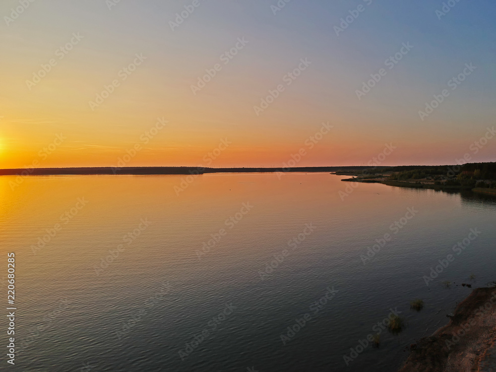  Beautiful sunset on German lakes. The lakes lie near Bohemia and Poland under the Berlin. The sunset has beautiful yellow and orange colors and you can see the waves of the lake and the sandy beach.