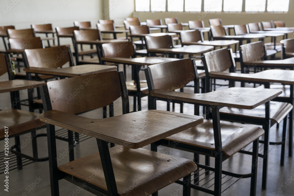 Fototapeta premium Empty classroom with vintage tone wooden chairs. Back to school concept.