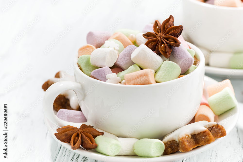 cocoa with colorful marshmallows in cup and Christmas cookies on white table cocoa with colorful marshmallows in cup and Christmas cookies on white table