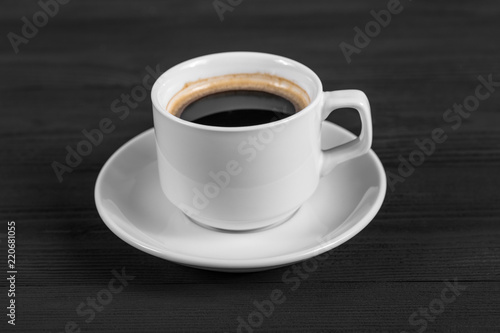 Black coffee in white cup on black wood background