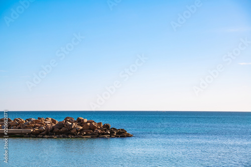 Breakwater from rocks in sea under sky